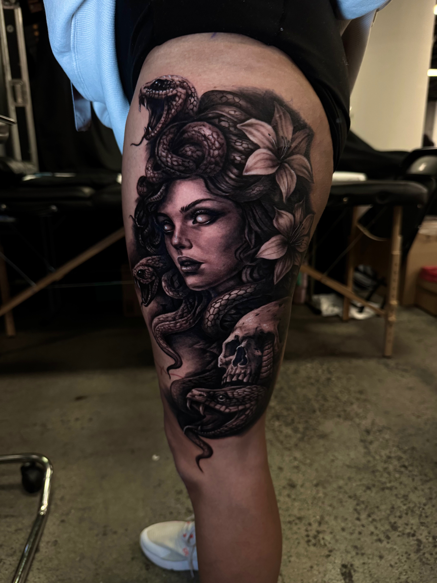Black and grey Medusa tattoo with snakes and skull on the thigh