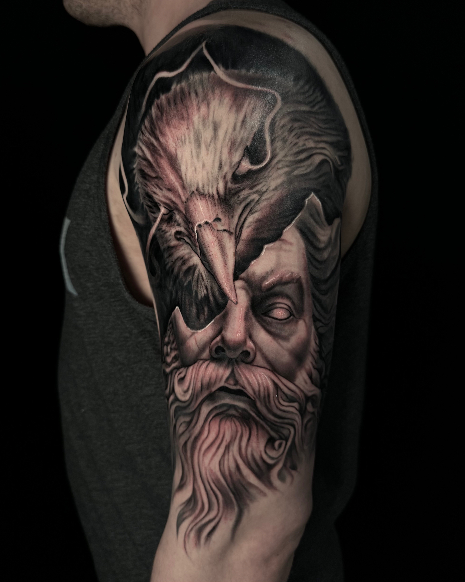 Black and grey sleeve tattoo featuring Odin and a raven